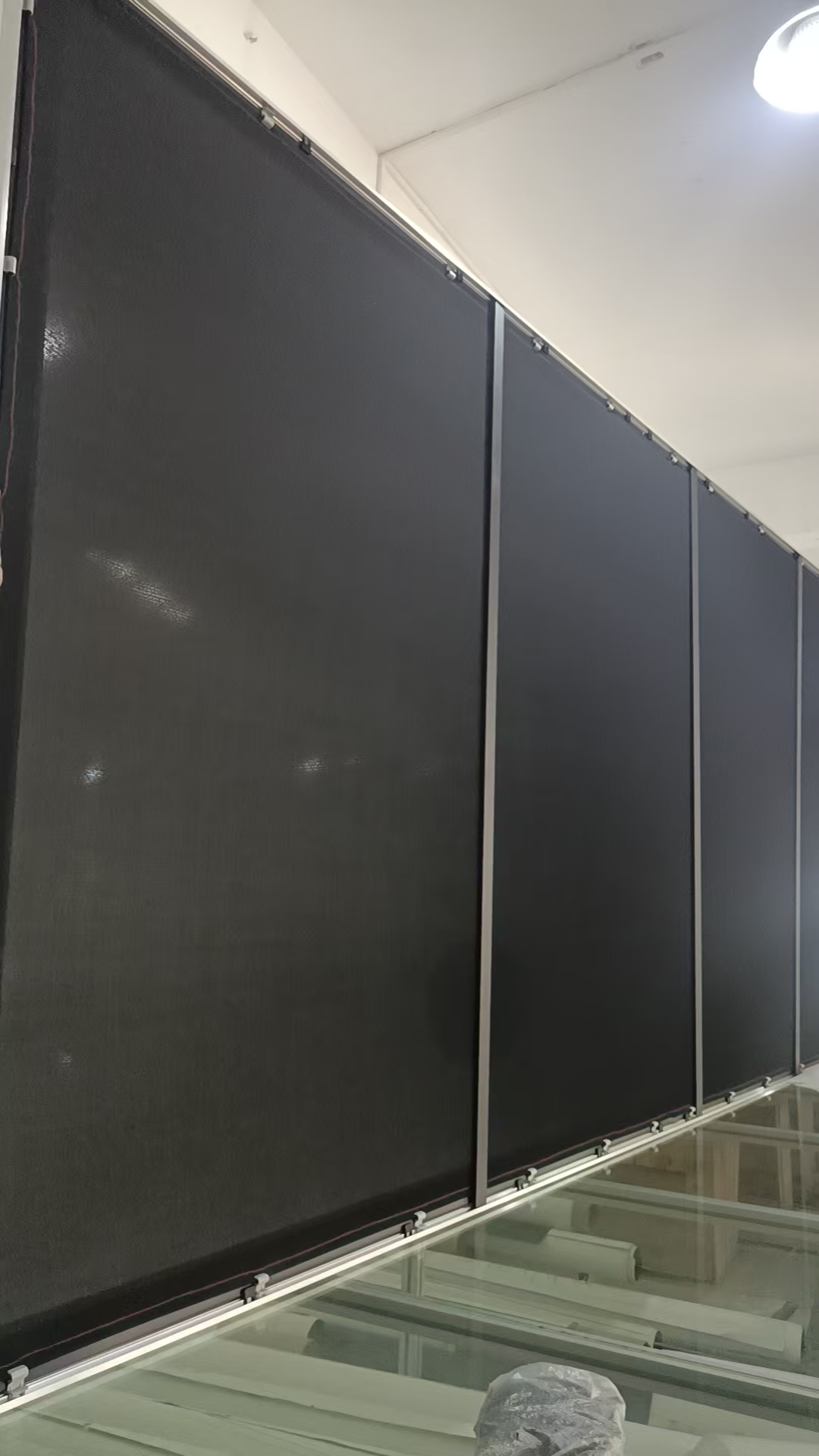 Side view of large custom projection screen during factory assembly